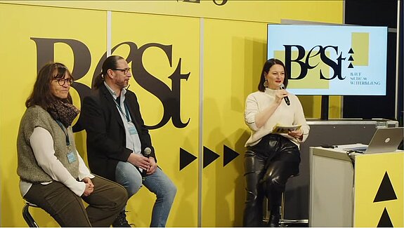 Zwei Mitarbeiter/innen der Stipendienstelle Wien werden auf der BeSt Messe zum Thema Studienförderung befragt