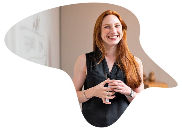 Frau mit Stift in Händen steht vor Whiteboard